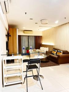 een woonkamer met een tafel en een bank bij Mercu Summer Suites KLCC By Minutepointhome in Kuala Lumpur