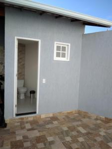 ein graues Haus mit einer Toilette und einem Fenster in der Unterkunft Casa em Cabo Frio in Cabo Frio