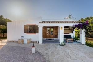 una casa bianca con patio e vialetto di VILLA GREAT PARADISE a San Jose de sa Talaia