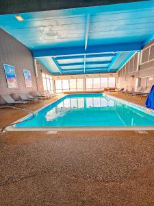 Comfort Inn Hyannis - Cape Cod في هيانيس: مسبح كبير في مبنى ذو سقوف زرقاء