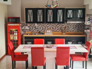 a kitchen with a white table and red chairs at Apartamento Riviera, lake Panajachel in San Jorge La Laguna