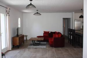 スラック・シュル・メールにあるMaison à SOULAC sur Mer avec Jardinの赤いソファとテーブルのあるリビングルーム