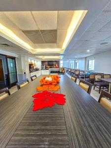 a conference room with a long table with red flowers on it at Comfort Inn Hyannis - Cape Cod in Hyannis