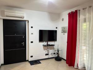 sala de estar con TV y cortina roja en Apartment Sabine, en Roma