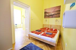 een slaapkamer met een bed in een kamer met gele muren bij Supreme Astoria Semmelweis in Boedapest