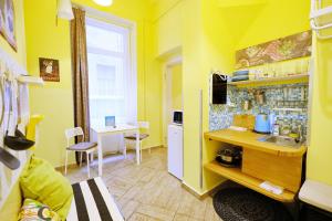 een gele keuken met een wastafel en een tafel bij Supreme Astoria Semmelweis in Boedapest