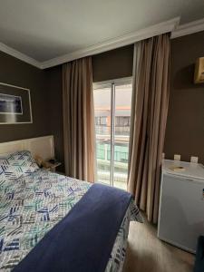a bedroom with a bed and a large window at HOTEL PERDIZES - FLAT Executivo - 1204 in São Paulo
