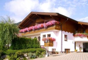 una casa bianca con dei fiori sul lato di Ferienwohnungen Haus Sonnenschein a Flachau