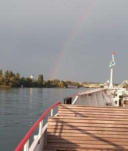 a boat on the water with a rainbow in the sky at Sonniges 1-Zimmerappartement mit Blick über Kreuzlingen in Kreuzlingen