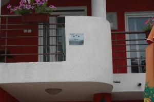 a white wall with a sign on the side of a building at Lukic Apartmani in Bar