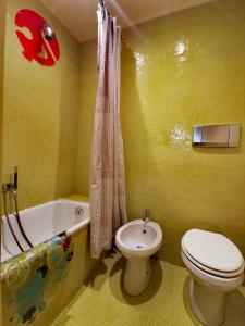 een gele badkamer met een toilet en een bad bij Perugia Abbraccio Etrusco in Perugia