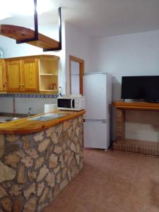 a kitchen with a stone counter and a refrigerator at Casa rio gallego in Gallego