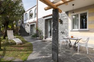 une terrasse avec une table et des chaises devant une maison dans l'établissement Villa Ani, à Ascona