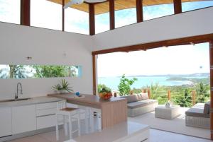 una cucina con armadi bianchi e un soggiorno con finestre di Full seascape luxury villa large outdoor area! a Ko Samui