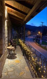a patio with a table and lights on a fence at Charoula Pavliani Fthiotidas in Pavliani