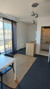 an empty living room with a table and a kitchen at Apartament przy centrum in Koszalin
