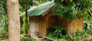 湄宏順的住宿－ลิ้นฟ้าแคมปิ้งรีสอร์ท，一座带绿色屋顶的小型木制建筑
