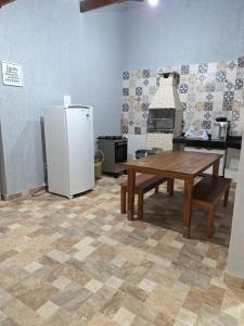 eine Küche mit Kühlschrank, Tisch und Herd in der Unterkunft Casa em Cabo Frio in Cabo Frio