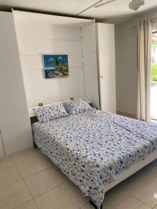 sypialnia z łóżkiem z niebieską kołdrą w obiekcie Joli appartement avec vue sur la piscine w mieście Boca Chica