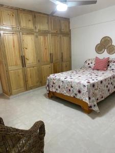 sypialnia z łóżkiem i drewnianymi szafkami w obiekcie Joli appartement avec vue sur la piscine w mieście Boca Chica