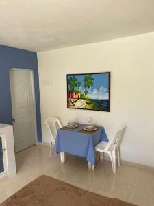 jadalnia z niebieskim stołem i białymi krzesłami w obiekcie Joli appartement avec vue sur la piscine w mieście Boca Chica