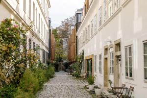 an alley between two white buildings with plants at Kleines Stadthaus in Toplage in Vienna