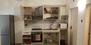 una piccola cucina con lavandino e forno a microonde di Monolocale Palermo torretta a Torretta