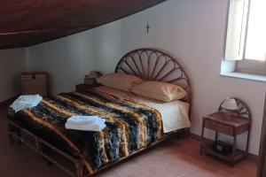 Schlafzimmer mit einem großen Bett mit einem Kopfteil aus Holz in der Unterkunft Casa “Lo scazzamauriello” in Garzano