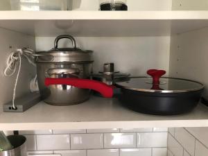 a pot and a pan on a shelf in a kitchen at STUDIO COSY STRASBOURG CENTRE TRAM in Strasbourg +4 photos