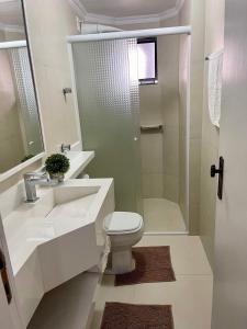 een badkamer met een wastafel, een toilet en een douche bij Apto 3 dorm completo - 100m Praia - Meia Praia in Itapema
