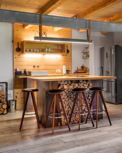 a kitchen with a wooden counter and stools at La Brazi - by 663A Mountain Chalet in Porumbacu de Sus
