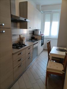 een keuken met een fornuis, een wastafel en een tafel bij Appartamento Sara in San Donato Milanese