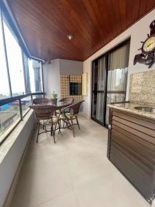 Una cocina y un comedor con mesa y sillas. en Apto 3 dorm completo - 100m Praia - Meia Praia, en Itapema 5 fotos más