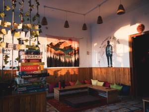 una stanza con un divano e una pila di libri di The Hostel Stories, Bir - Landing Site a Bīr