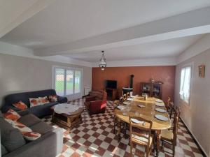 a living room with a couch and a table at Maison 8-10 personnes in Vrocourt