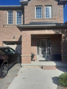 a car parked in front of a brick house at One bedroom basement suite with private living room and laundry. in Brampton