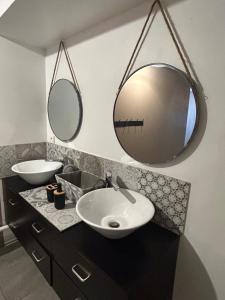 uma casa de banho com dois lavatórios e dois espelhos em Suite parentale 50m2 em Châtillon-Saint-Jean