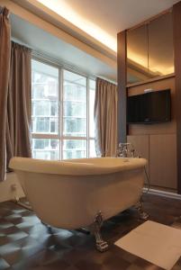 a bath tub in a bathroom with a large window at Park View KLCC ,by DeLive Home in Kuala Lumpur