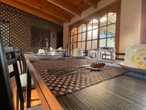a wooden table with utensils on top of it at Hostal Fernanda in Santa Cruz