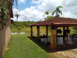 a gazebo in front of a body of water at Pousada e camping Canastra Mineira in São Roque de Minas