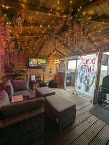 a living room with a couch and a tv on a ceiling at FINN VILLAGE - Loch Lomond Sunset Glamping Pod - Private Ofuro HOT TUB in Drymen