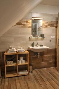 een badkamer met een wastafel en een spiegel bij Pension Kotva in Beroun