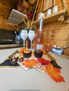 a table with two wine glasses and cupcakes on it at FINN VILLAGE - Loch Lomond Sunset Glamping Pod - Private Ofuro HOT TUB in Drymen