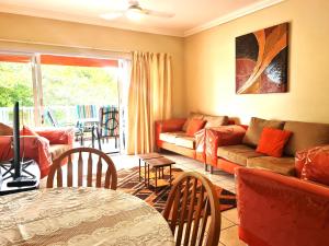 a living room with a couch and a table at Kingfisher E in Shelly Beach