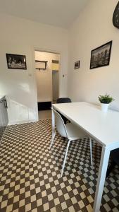 a white table and chair in a room with a checkered floor at Warszawa Krucza Pokoje in Warsaw