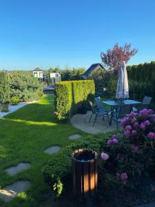 un giardino con patio, tavolo e ombrellone di Premium Residence SPA & Garden a Glińcz