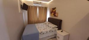 a small bedroom with a bed and a box at casa nas marinas boa vista in Boa Vista Parecida