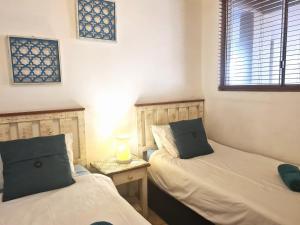 a bedroom with two beds and a window at Santorini 105A in Margate +10 photos