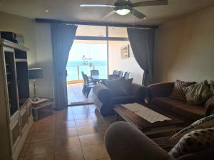 a living room with a couch and a table with a view of the ocean at Santorini 105A in Margate