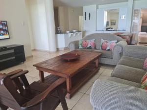 a living room with a wooden table and chairs at Santorini 106A in Margate